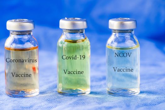 Corona virus and Covid - 19 new vaccine in ampules, different color variations of vaccine on the blue background