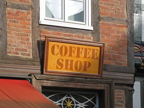 A wooden sign hanging in front of a coffee shop, Celle, Lower Saxony, Germany.