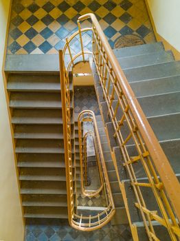 Top down look to spiral staircase with yellow railing