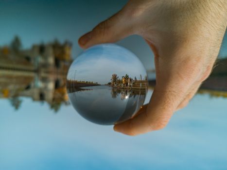 Old city port reflected in crystal glassy lensball