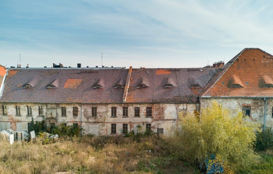 Ruins of old building full of windows and peeleng facade plasters