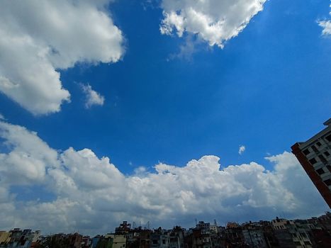 white cloud on blue sky with city