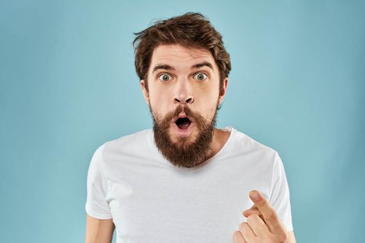 Man with disgruntled facial expression gesturing with hands studio lifestyle blue background. High quality photo