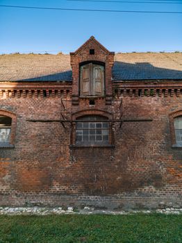 Old barn made by red brick full of horses