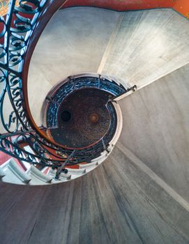 Upward view to old spiral staircase with pattern on ceiling