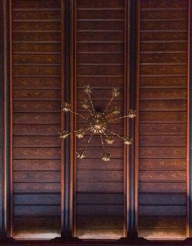 Upward view to large chandelier and wooden ceiling