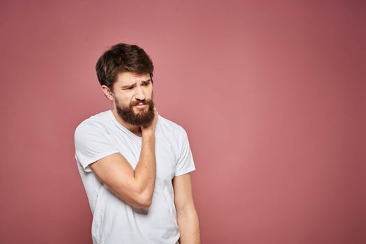 Man in white t-shirt emotions lifestyle facial expression cropped view pink background. High quality photo