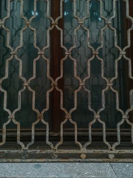 Metal ornamental lattice in front of old window