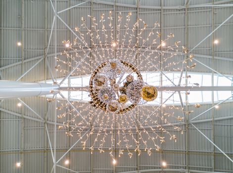 Upward view to large chandelier with lights and christmas balls