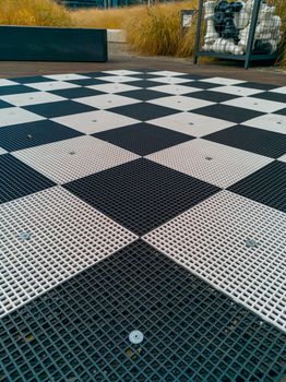 Plastic chessboard with plastic chess pieces at corporate square