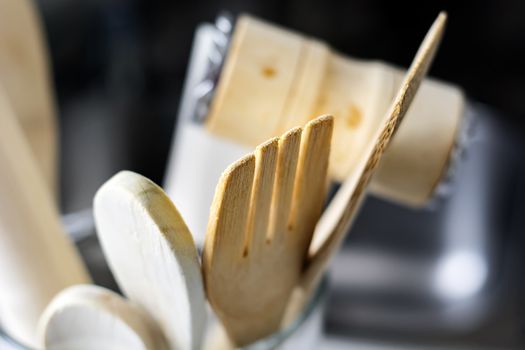 close-up view of a group of wooden kitchen utensils. Selective focus on the fork. Tools for cooking