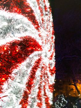 Glowing red and white christmas decorations in park at night