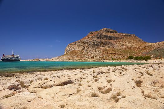 2019, JUNE, THE 4TH: - GREECE, THE CRETE ISLAND, GRAMVOUSA - The castle on the top of the mountain and the people on the beach below it.