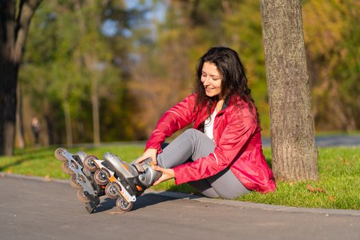 Active leisure. A sportive girl is rollerblading in an autumn park.