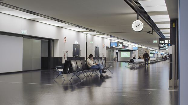 Vienna, Vienna/Austria - November 2nd 2020: Passengers waiting at Vienna airport. Only a few people travelling and a lot of closed gates.