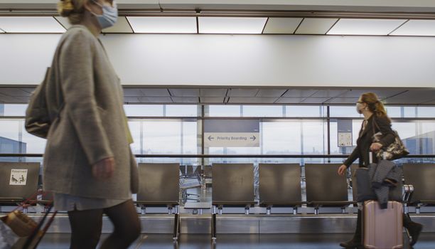 Vienna, Vienna/Austria - November 2nd 2020: Passengers walking to departure gates at Vienna airport. Only a few people travelling and a lot of closed gates.