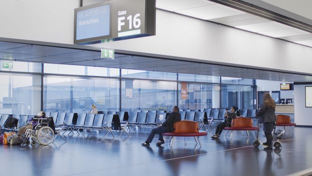 Vienna, Vienna/Austria - November 2nd 2020: Passengers waiting at Vienna airport. Only a few people travelling and a lot of closed gates.