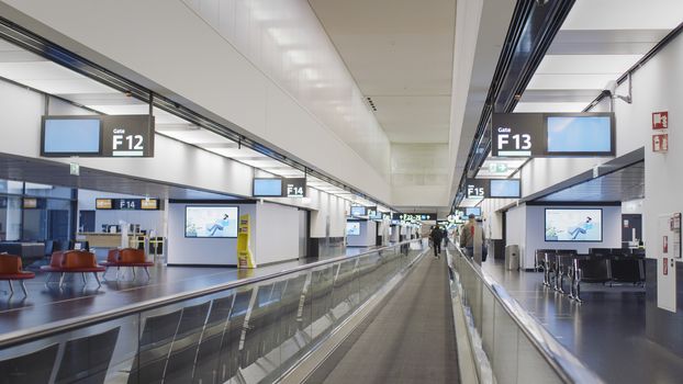 Vienna, Vienna/Austria - November 2nd 2020: Passengers walking to departure gates at Vienna airport. Only a few people travelling and a lot of closed gates.
