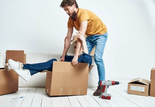 young married couple boxes with things moving room interior fun. High quality photo