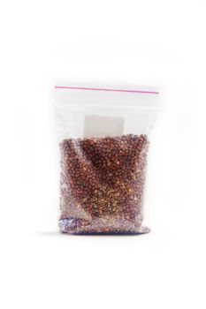 Chinese radish seeds in a package for germination on a white background.