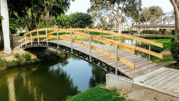 Bridge over a lake in a forest with trees and flowers