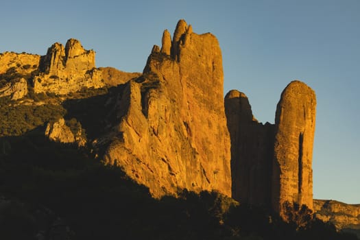 Mountains of the Mallos de Riglos, vertical rock walls at sunset, a famous place for climbing near the Gallego river, in the pre-Pyrenees, Huesca province, Aragon, Spain.