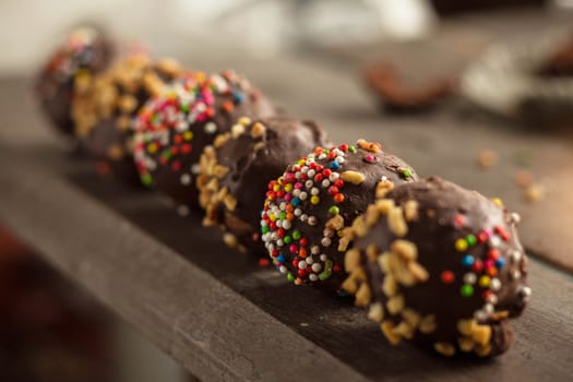 Colorful chocolate on the wooden table.