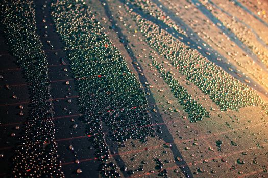 Colorful drops of water on the glass with the sun in the morning.