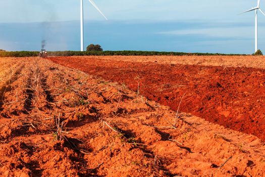 rural field with tractors that plowing at the blue sky.