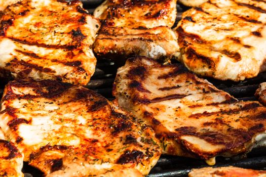Grilling pork steaks. Delicious meat steaks close up cooking on the barbecue grill