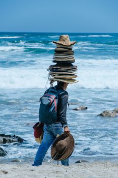 Seller of hats with many hats on his head, on a beach in Lima - Peru