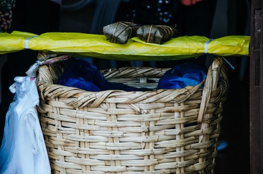 Peruvian food : tamal above the basket, called Tamal which is prepared from cooked corn mixed with chicken or pork and wrapped in banana leaves. It is eaten for breakfast or as appetizer at lunch