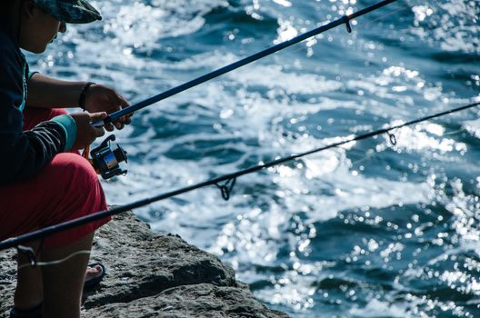 Fisherman on the seashore with his fishing rod