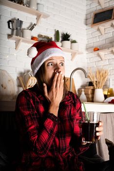 Movie night. Young woman in 3D glasses sitting on the sofa watching horror movies at home at christmas night