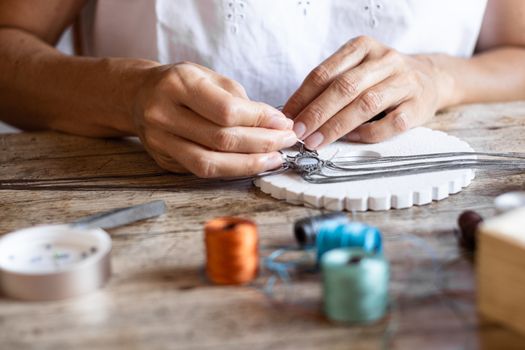 Close up of female hands making macrame jewel with a precious stone in the center - Work from home to change your life for the better with creative activity - Combine business with pleasure concept