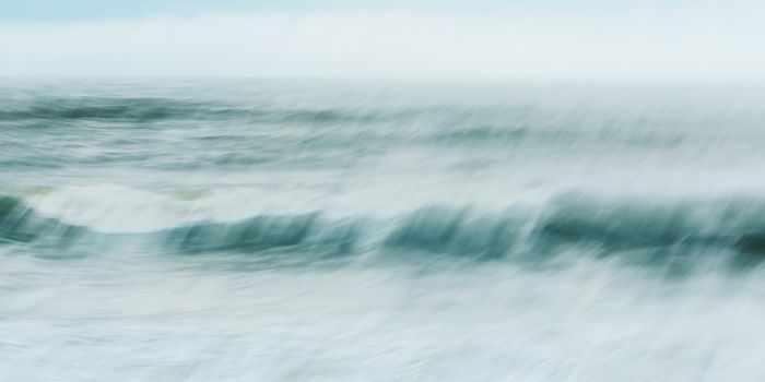 Intentional camera movement of ocean wave, abstract blurred sea background