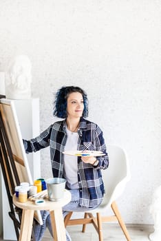 Creative woman artist painting a picture working in her studio