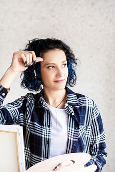 Creative woman artist painting a picture working in her studio