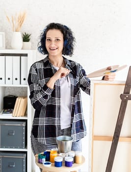 Creative woman artist painting a picture working in her studio