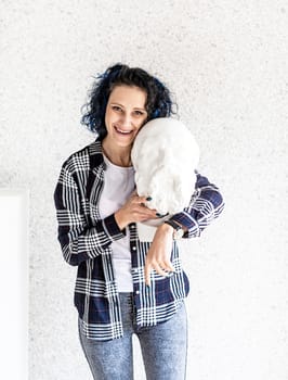 Portrait of a smiling woman artist in her studio holding gypsum sculpture