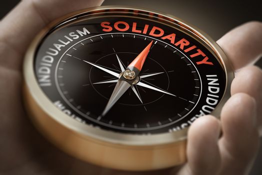 Man hand holding compass with needle pointing the word solidarity. Sociology concept. Composite image between a hand photography and a 3D background.