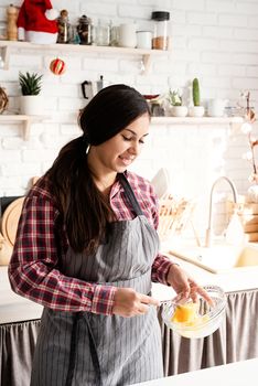 Cooking and baking. Young latin woman whisking eggs cooking at the kitchen