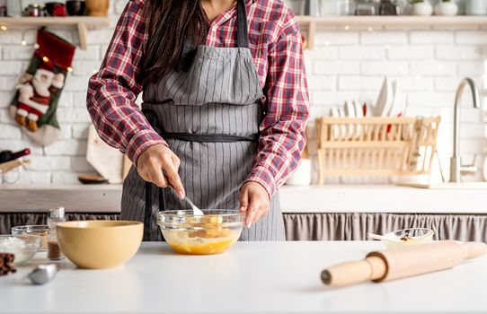 Cooking and baking. Young latin woman whisking eggs cooking at the kitchen