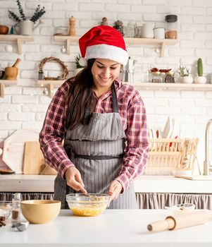 Cooking and baking. Young latin woman whisking eggs cooking at the kitchen