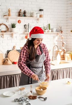 Cooking and baking. Young latin woman whisking eggs cooking at the kitchen