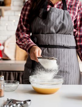 Cooking and baking. Young latin woman pouring flour to the dough cooking at the kitchen