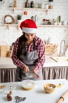 Cooking and baking. Young latin woman pouring flour to the dough cooking at the kitchen