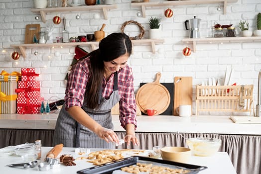 Cooking and baking. Young brunette woman baking cookies at the kitchen