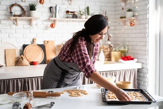 Cooking and baking. Young brunette woman baking cookies at the kitchen