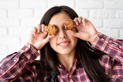 Cooking and baking. Happy woman in apron holding star shaped cookies in front of her eyes